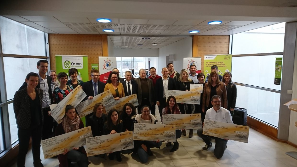 Remise des prix : Commerçants Fédérez vos talents à la CCI NORD ISERE. Un groupe d'une trentaine de personnes posent pour la photo. Certains ont entre les mains des faux chèques qu'ils viennent de recevoir. Tout le monde est très souriants. Certaines personnes sont accroupis au premier rang pour permettre à tout le monde d'être visible sur la photo